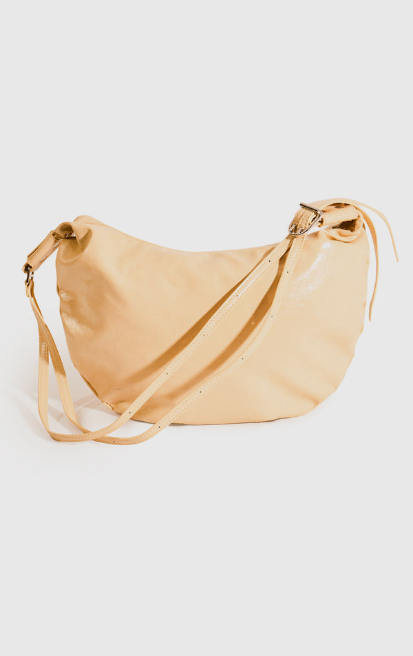 Stylized photo of the Yellow Faux Leather Dumpling Shoulder Bag on minimal setup