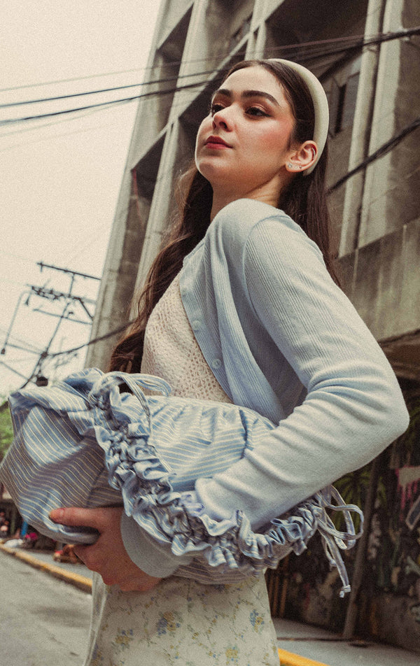 Campaign photo of the Blue Nylon Stripes Dumpling Shoulder Bag with Ruched Handle worn by a model with outfit 