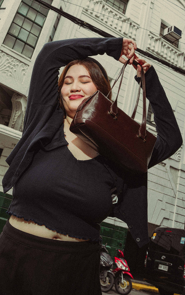 Campaign photo of the Brown Faux Leather Bowling Bag worn by a model with outfit 