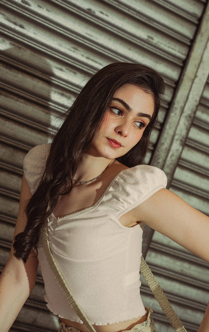 Campaign photo of a woman wearing the offwhite Textured Ribbed Jersey Corset-Like Top with Picoting and Bow from the Back to School collection of Just G Philippines.