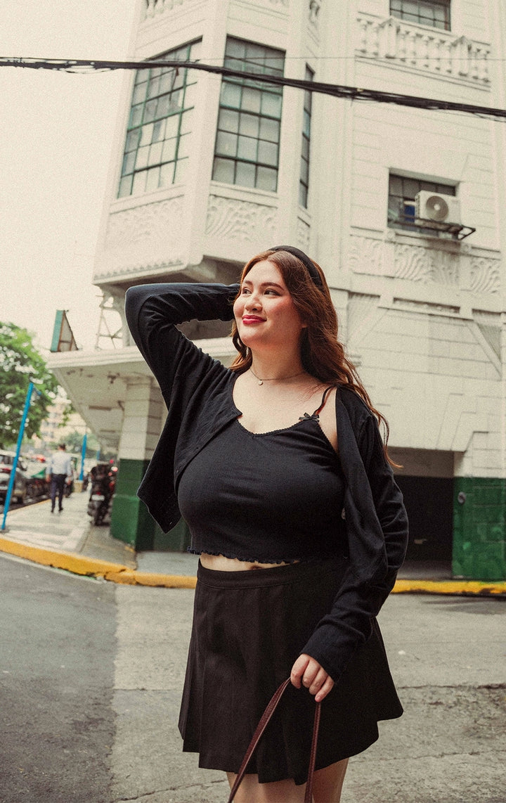 Campaign photo of a woman wearing the Pointelle Ribbed Jersey Tank Top with Lace Trim and Bows in black from the Back to School collection of Just G Philippines.