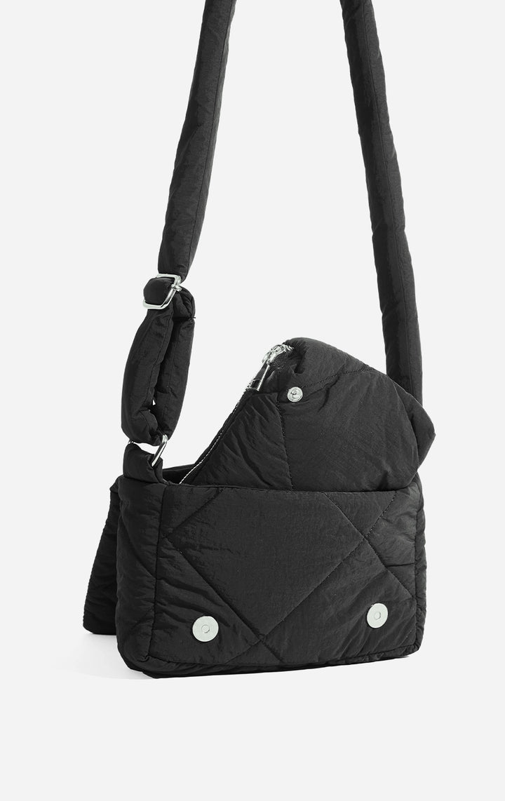 Stylized photo of the Black 2-in-1 Sling with Pouch Puffer Bag on minimal setup