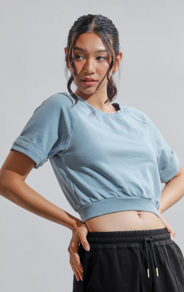 Stylized image of model in blue Terry Raglan Roundneck Tee with Ribbing from Just G Philippines, styled for an active lifestyle.