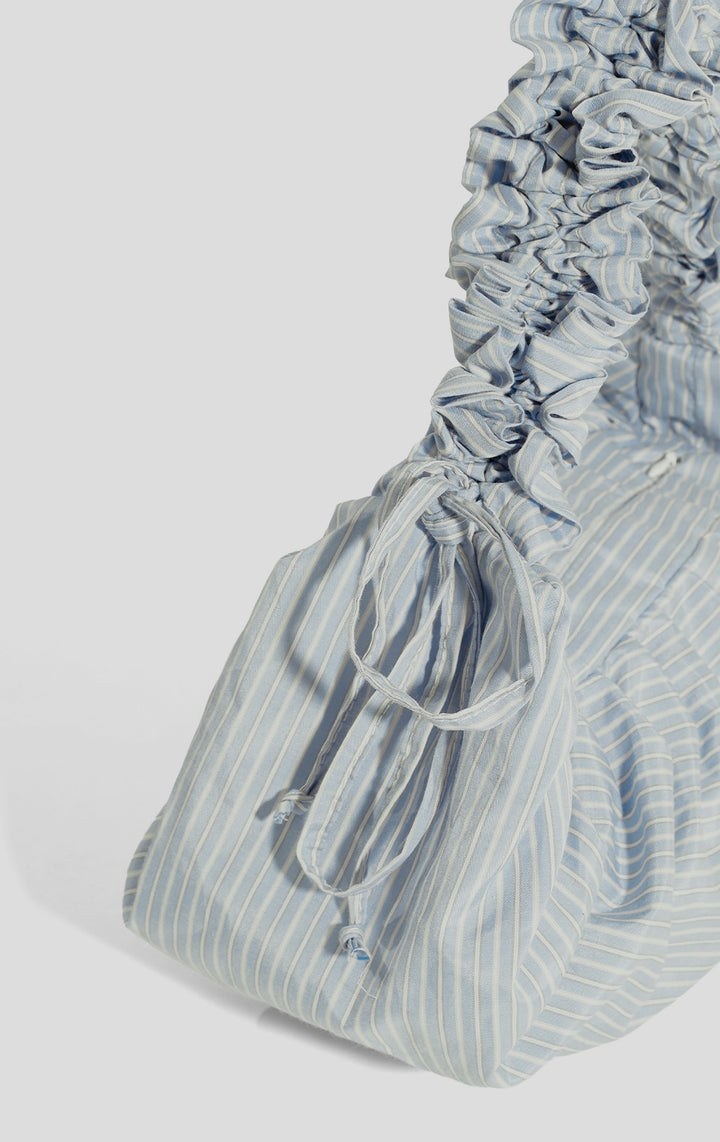 Close-up of the blue nylon stripes and ruched handle of the Dumpling Shoulder Bag