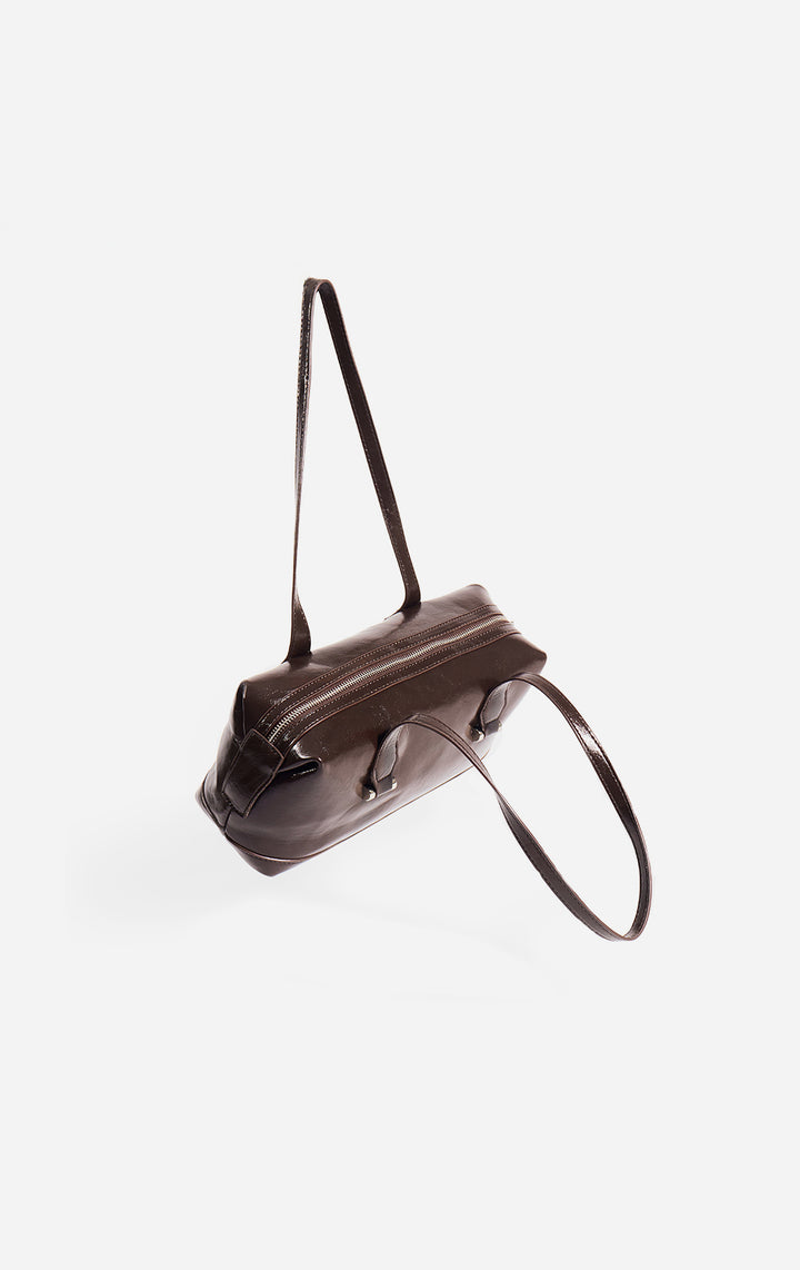 Stylized photo of the Brown Faux Leather Bowling Bag on minimal setup