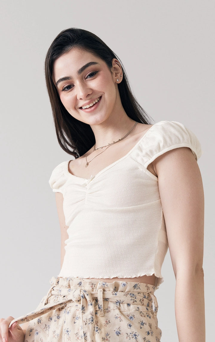 Stylized photo of model in the offwhite Textured Ribbed Jersey Corset-Like Top with Picoting and Bow, styled for casual hangouts from Just G Philippines’ Back to School collection.