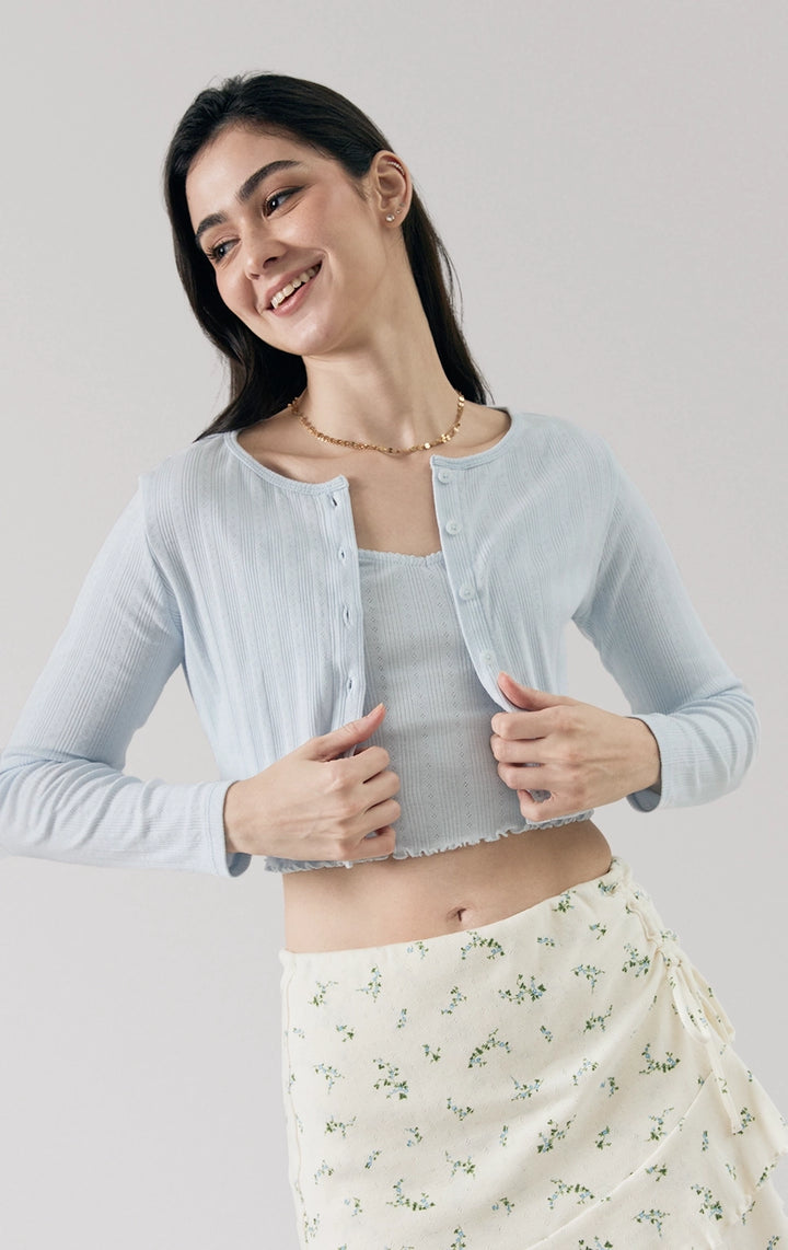 Stylized photo of model wearing the Pointelle Ribbed Jersey Long Sleeve Cropped Cardigan in blue, styled for cozy cafe hopping from Just G Philippines’ Back to School collection.