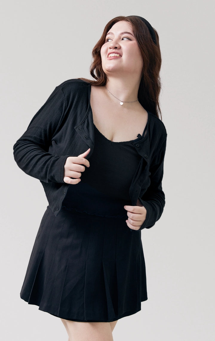 Stylized photo of model wearing the Pointelle Ribbed Jersey Long Sleeve Cropped Cardigan in black, styled for cozy cafe hopping from Just G Philippines’ Back to School collection.