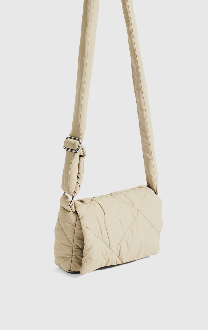 Stylized photo of the Khaki 2-in-1 Sling with Pouch Puffer Bag on minimal setup