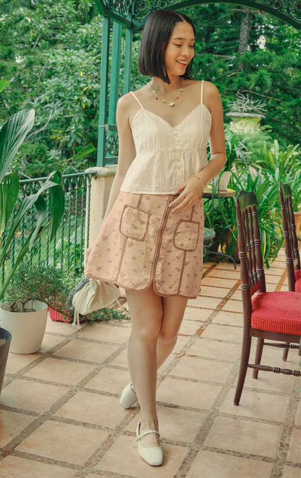 Campaign photo of the zip up a-line floral mini skirt with contrast piping detail that shows how it looks when worn, from the Just G Love In Bloom collection