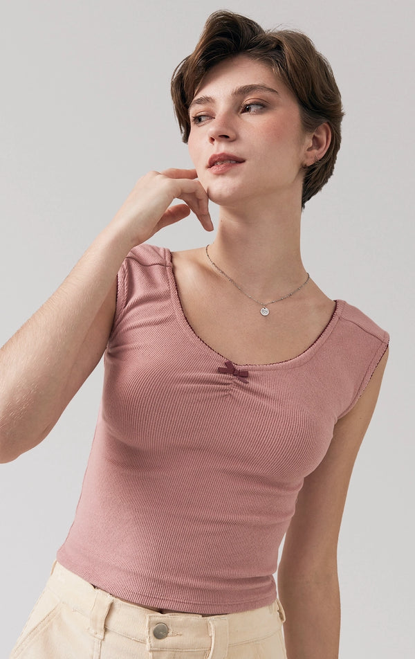 A stylized fashion photo of the ribbed jersey ruched bardot top with lace and bow that is worn with bottoms and accessories by a model to see it in motion