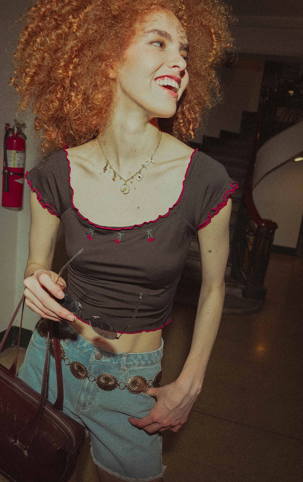 Campaign photo of the lettuce edge scoop neck crop top with cherry embroidery that shows how it looks when worn, from the Just G Urban Flora collection