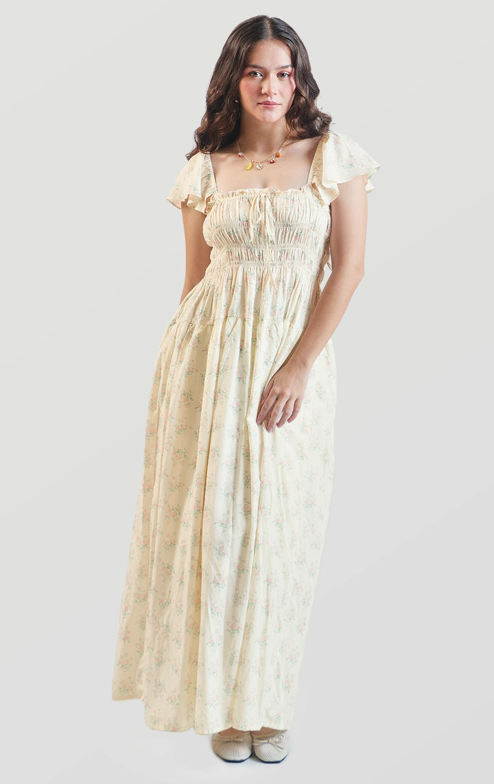 Full front view of a model wearing the floral smocked maxi dress with flutter sleeves and square neckline by Just G Philippines
