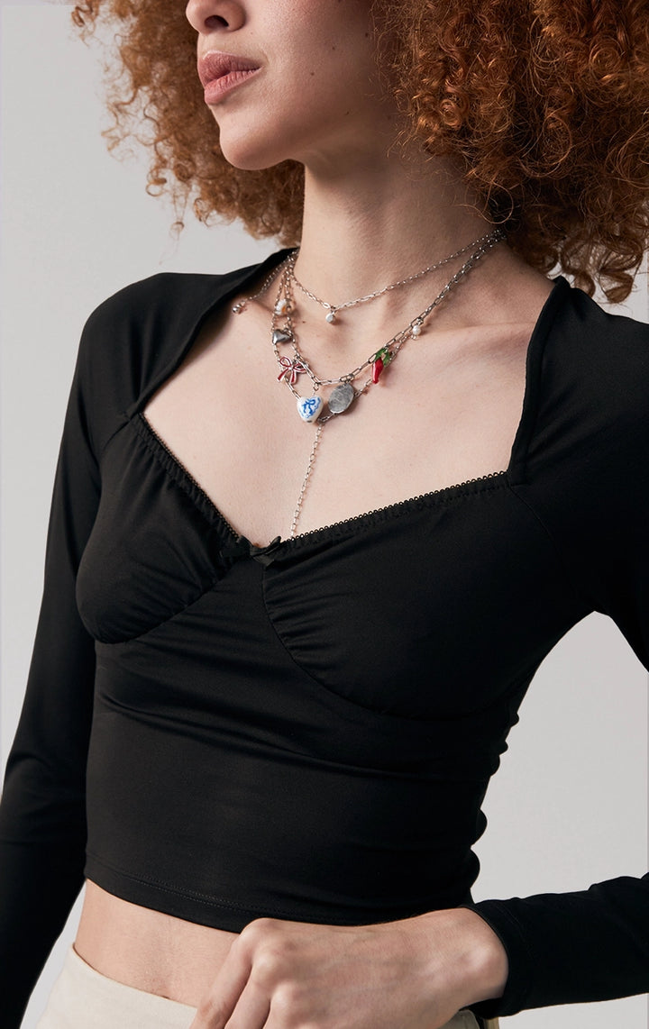 Front detail close-up of the lace trim and bow on the sweetheart neckline of black top by Just G Philippines