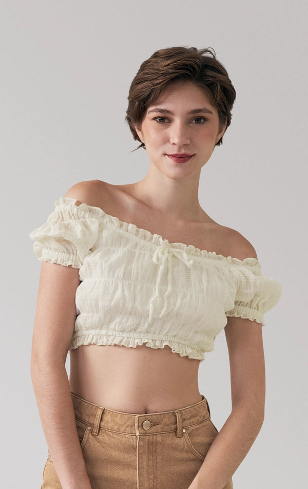 A stylized fashion photo of the smocked peasant top that is worn with bottoms and accessories by a model to see it in motion
