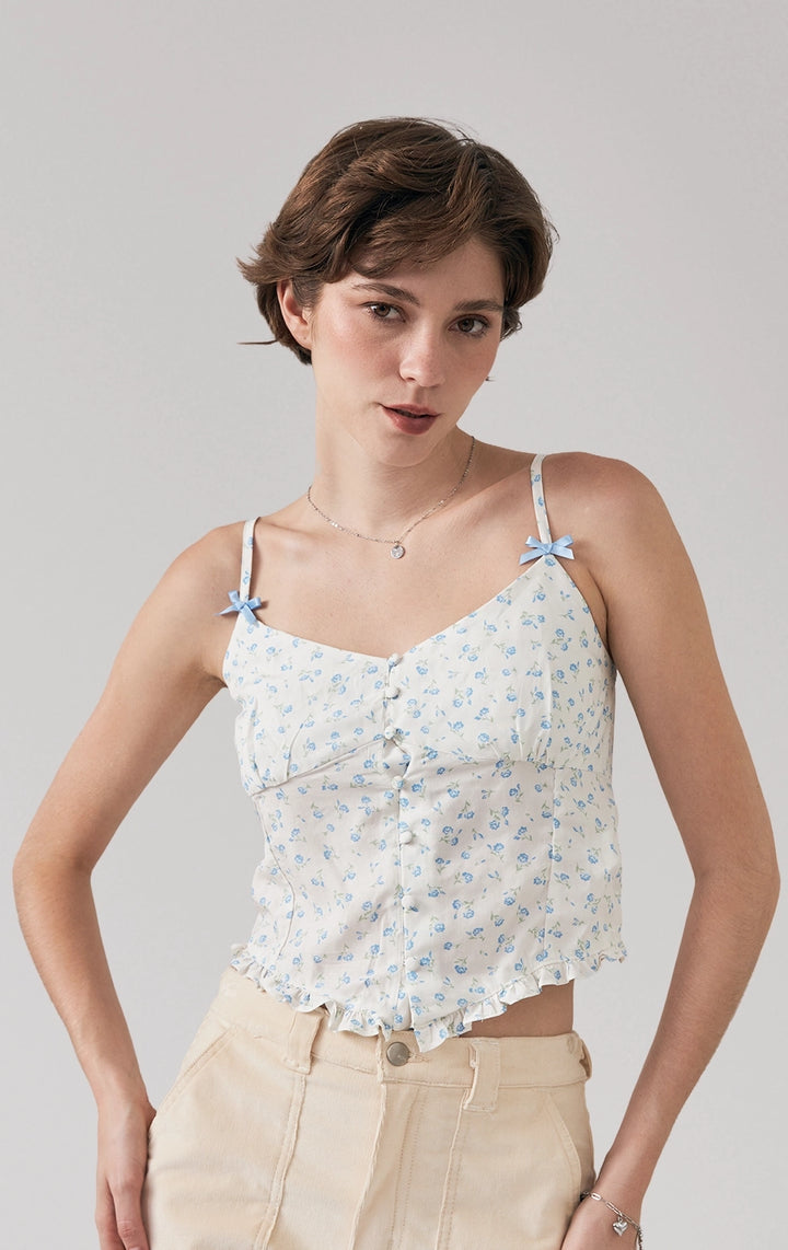 Stylized photo of model wearing the Floral Strappy Button Front Corset Top with Bows and Ruffled V-Hem styled for warm-weather cafe days from Just G Philippines.