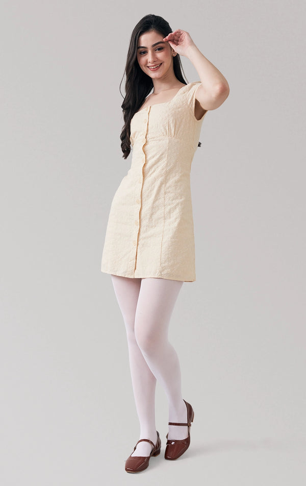 Full front view of a model wearing the mini dress with embroidered swiss cotton, buttons, and square neckline by Just G Philippines