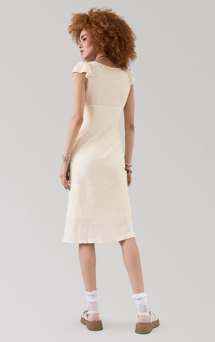 Full back view of woman in offwhite Flutter Sleeve Symmetrical Hem Midi Dress, highlighting the flowy hem and lightweight fabric. From Just G Philippines.