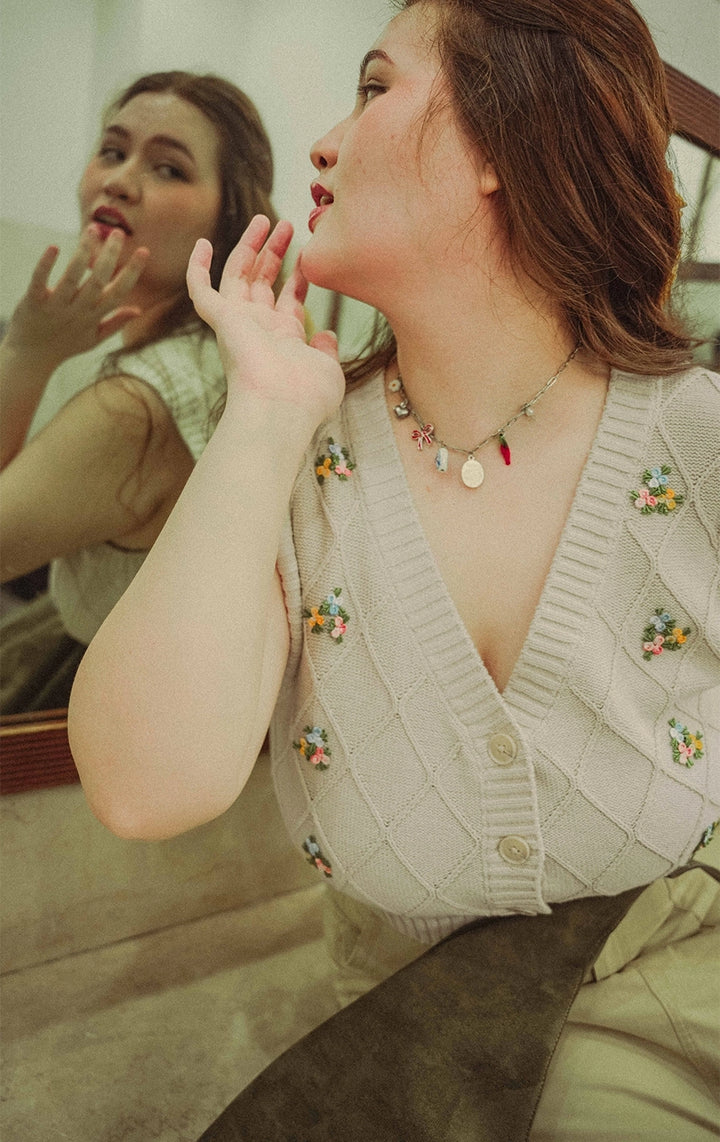 Campaign photo of woman wearing the Trellis Cable Knit Button Front Cropped Vest with Flower Bullion Embroidery in beige, from Gen Z brand Just G Philippines.