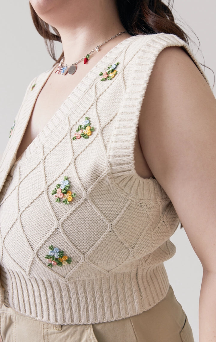 Close-up of front details of the Trellis Cable Knit Button Front Cropped Vest in beige, featuring cable stitches, buttons, and delicate bullion floral embroidery from Just G Philippines.