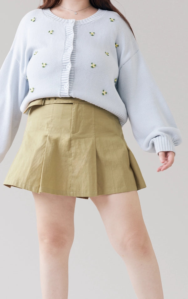 Stylized photo of model wearing the green Belted Pleated Mid Waist Skort styled for back to school, part of Just G Philippines’ latest collection.