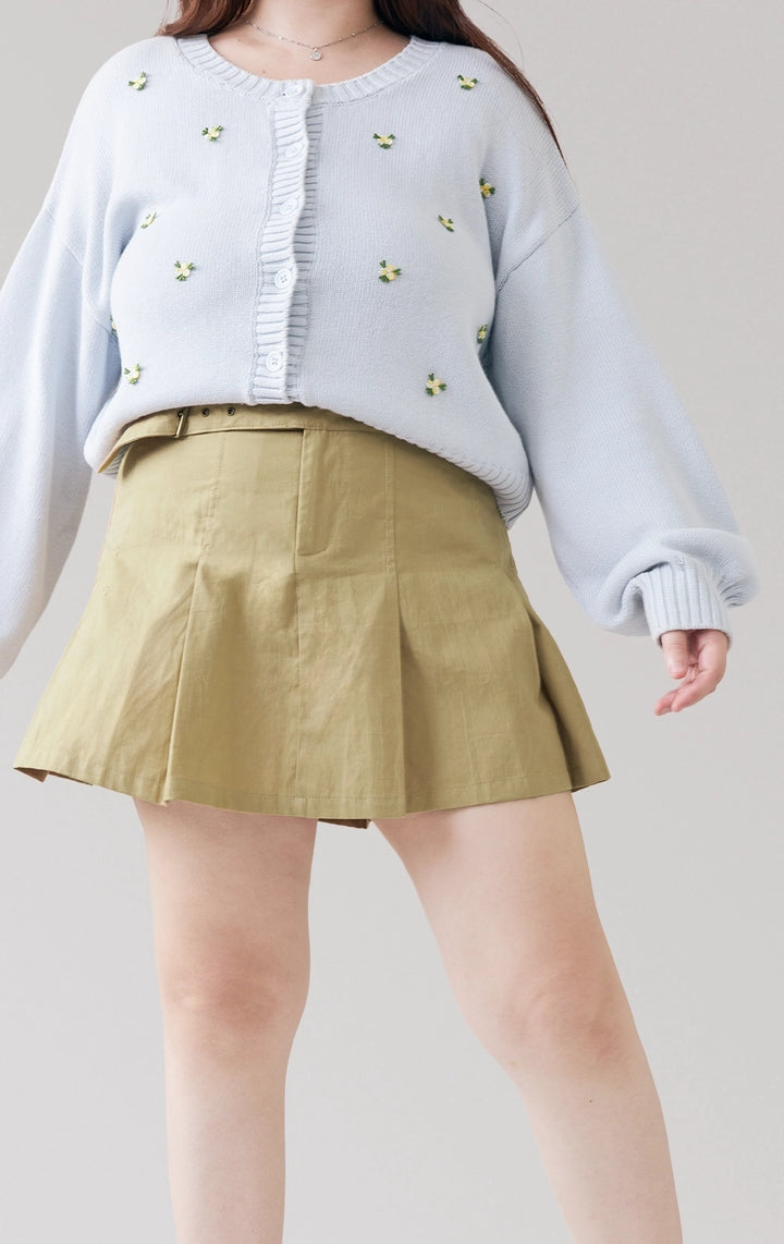 Stylized photo of model wearing the green Belted Pleated Mid Waist Skort styled for back to school, part of Just G Philippines’ latest collection.