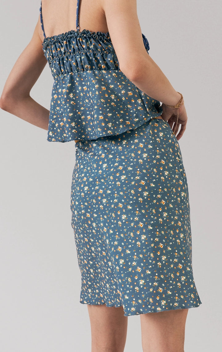 A stylized fashion photo of the ditsy floral top and skirt set that is worn by a model to see it in motion
