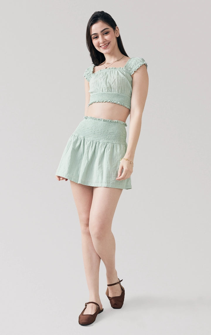 Full front view of woman in Textured Dobby Romantic Smocked Top and Skirt Set in sage green, showing the relaxed silhouette and fabric texture. From Just G Philippines.