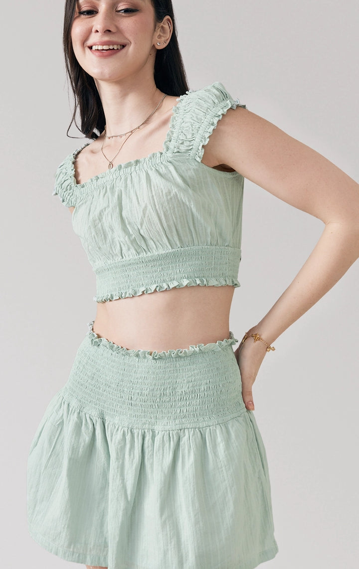 Stylized photo of model wearing sage green Dobby Romantic Smocked Top and Skirt Set in a relaxed, feminine silhouette from Just G Philippines.