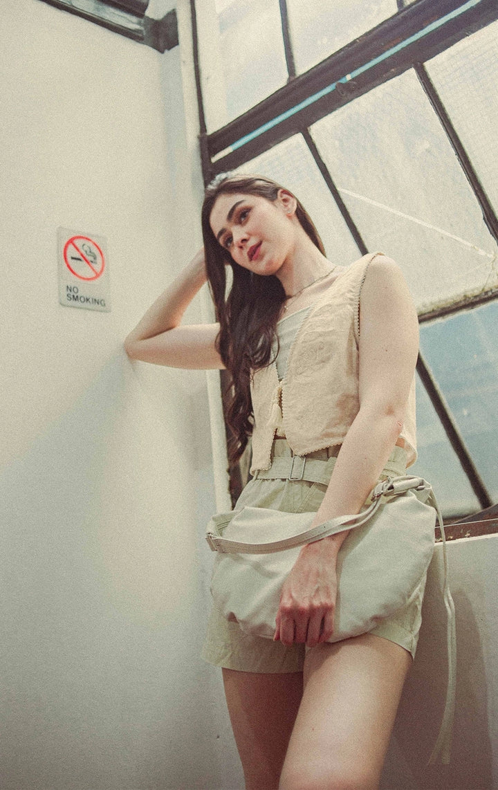 Campaign photo of woman wearing Cropped Linen-Like Tie Front Vest With Cross-Stitch Details And Lace in Beige from Gen Z brand Just G Philippines.